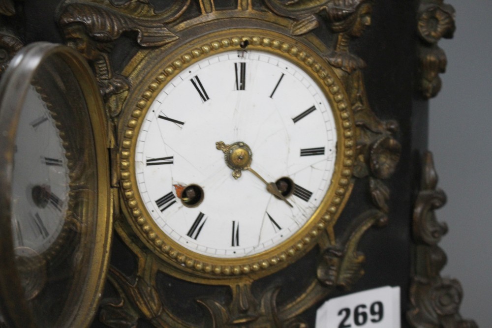 A Victorian bronze mounted black slate mantel clock, with enamelled dial, surmounted with figures of putti, height 48cm